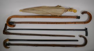 A collection of walking sticks including an ebonised stick with a hallmarked silver cuff, and a horn