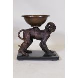 A bronze figure of a monkey bearing a bowl, mounted on a slate base, 37 x 20cms, 39cm high
