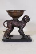 A bronze figure of a monkey bearing a bowl, mounted on a slate base, 37 x 20cms, 39cm high