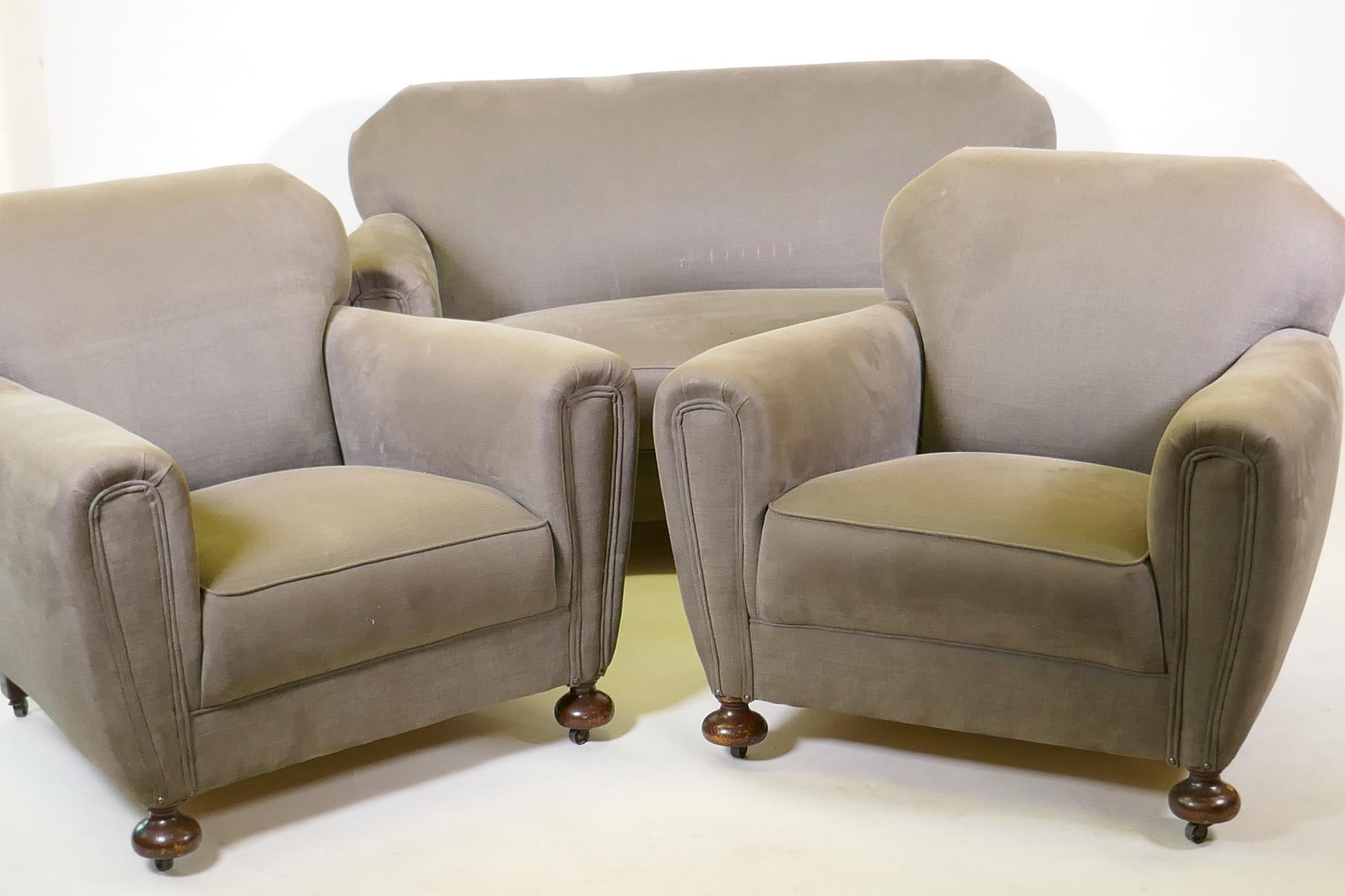 An Art Deco three piece suite, settee and two armchairs, well upholstered in a neutral fabric, 145cm
