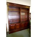 A mahogany bookcase, with two open upper sections over two base sections, fitted with cupboards,