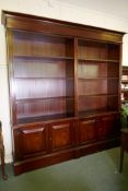 A mahogany bookcase, with two open upper sections over two base sections, fitted with cupboards,