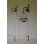 A pair of painted wrought iron garden display stakes and a hanging basket, 199cm