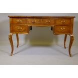 A French tulip wood and rosewood inlaid serpentine shaped five drawer kneehole desk, with gilt