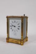 A C19th gilt brass carriage clock with five bevelled glass panels, the enamel dial with Roman