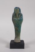 An Egyptian turquoise glazed faience shabti, mounted on a display base, 14cm high