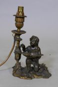 A bronze lamp in the form of a Putto bearing a vine leaf, 19cm high