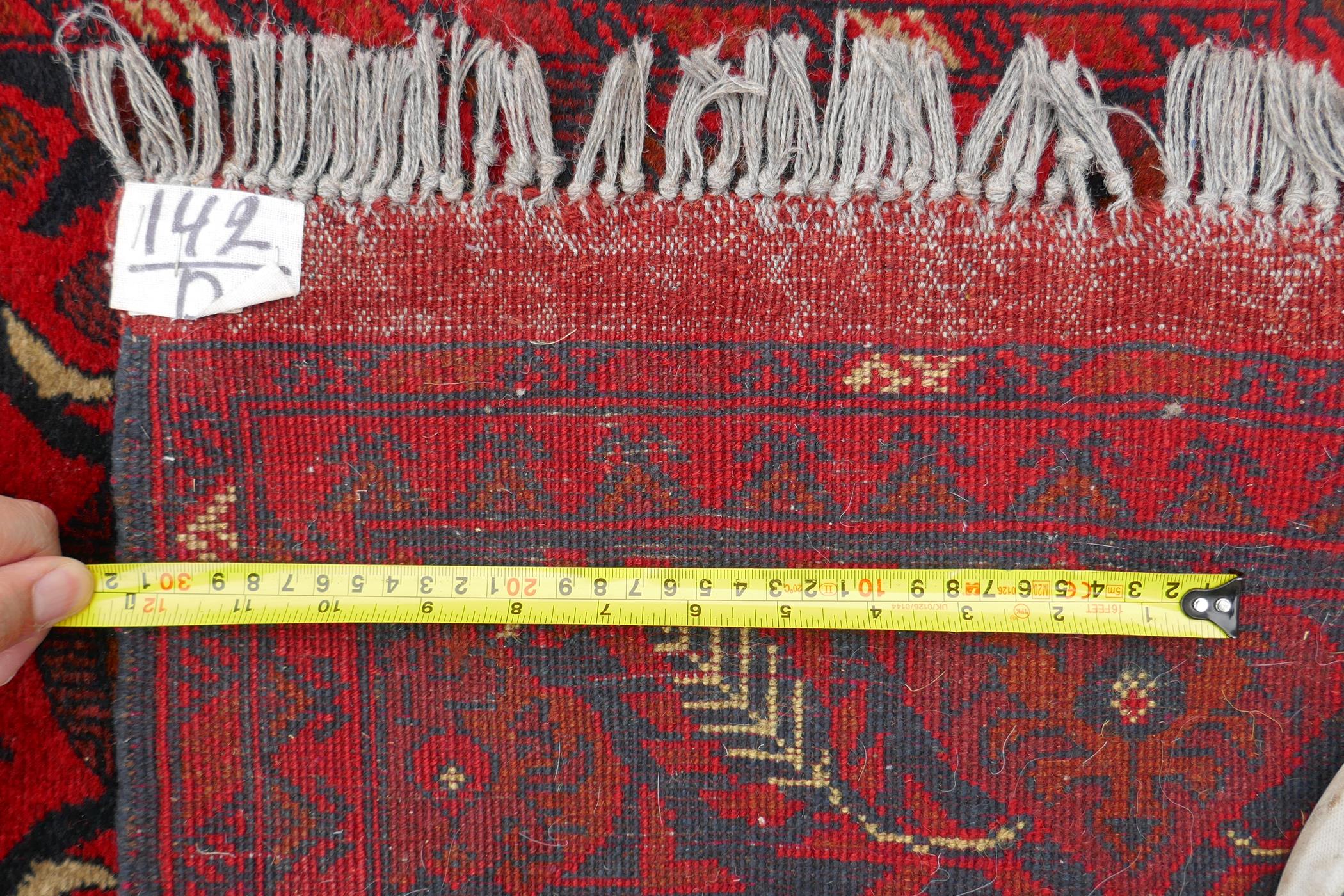 A Persian rich red ground wool runner with a floral medallion design and black borders, 33" x 116" - Image 5 of 5