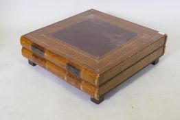 A low coffee table in the form of two leather covered books, with gilt tooled decoration, 68 x 65