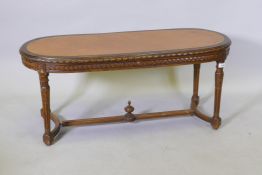 An early C19th carved walnut table, with inset leather top, raised on carved and fluted supports,