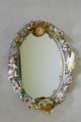 A C19th continental porcelain wall mirror, with putti and floral decoration, AF, 44cm high
