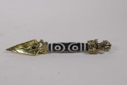 A Sino Tibetan gilt metal phurba with a Dzi bead handle, 17cm long