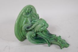 A green glazed grotesque majolica wall bracket, 19cm