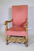 A C19th carved and gilt oak high back throne chair, with scrolled end arms, raised on carved