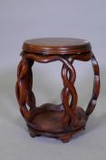 A Chinese hardwood barrel shaped stand, with silver wire inlaid top, raised on carved and pierced