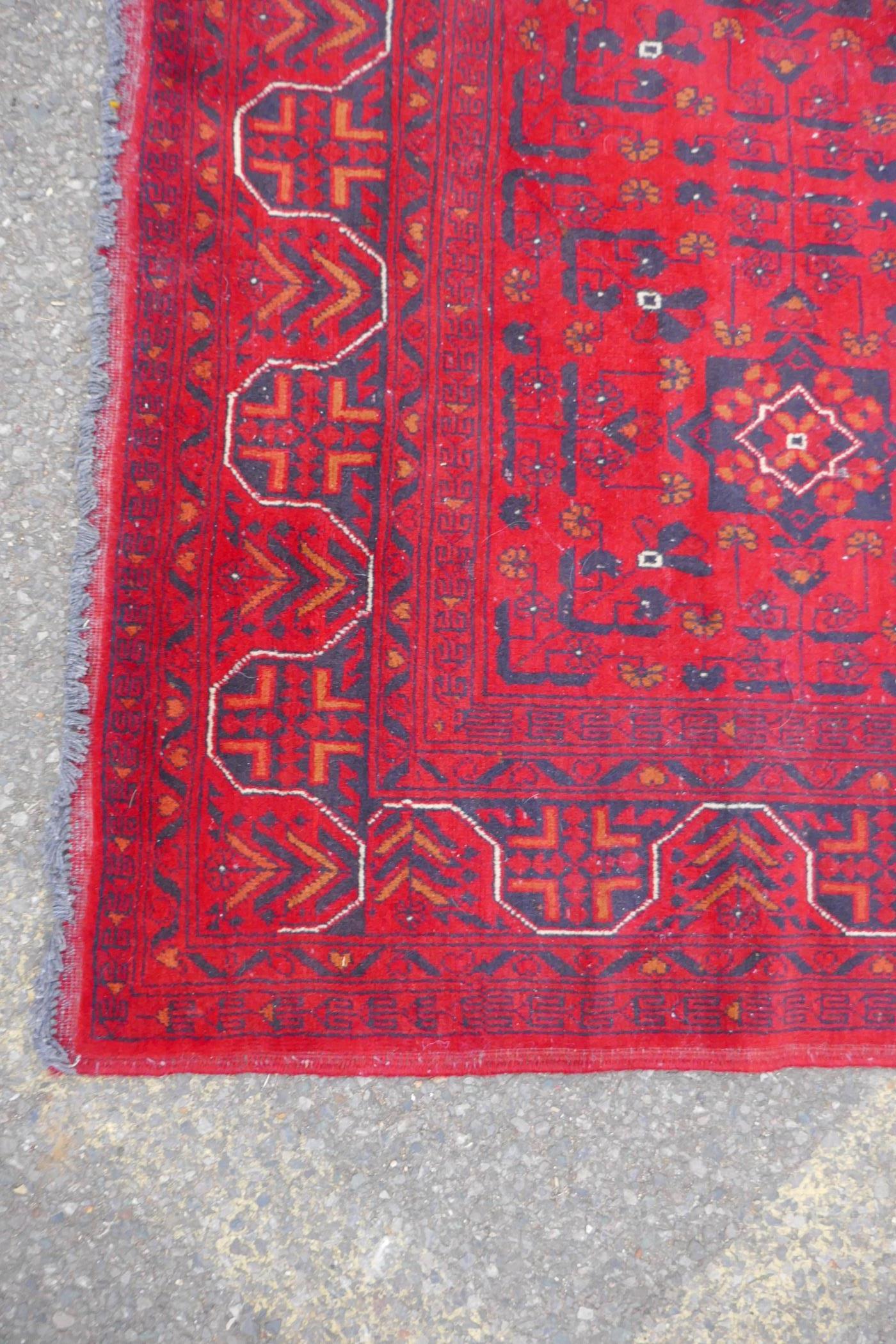 A Turkish deep red ground wool carpet with unique repeating floral geometric design, 165 x 230cms - Image 4 of 5