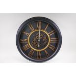 A wall clock with quartz movement and separately powered open cogwork, with bronzed Roman