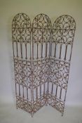 An arch top three fold iron garden screen with open scrollwork decoration, each panel 180 x 40cms