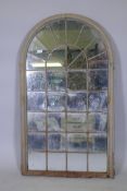 A dome top metal framed garden mirror with lattice decoration, 130 x 76cms