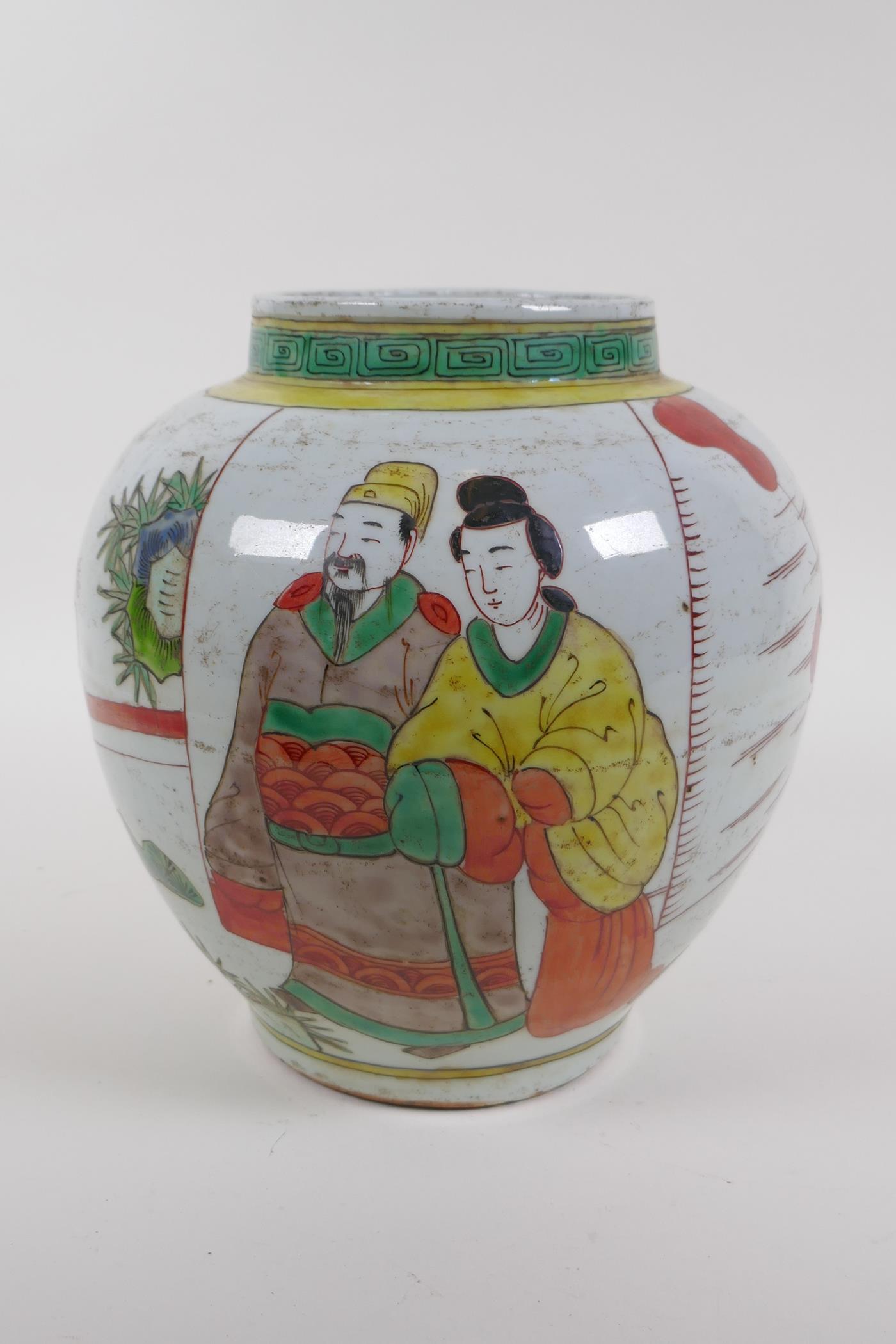 A Chinese Wucai pottery jar decorated with figures in a landscape, 21cm high