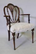 A late C18th/early C19th Hepplewhite elbow chair with carved and pierced back, raised on tapering