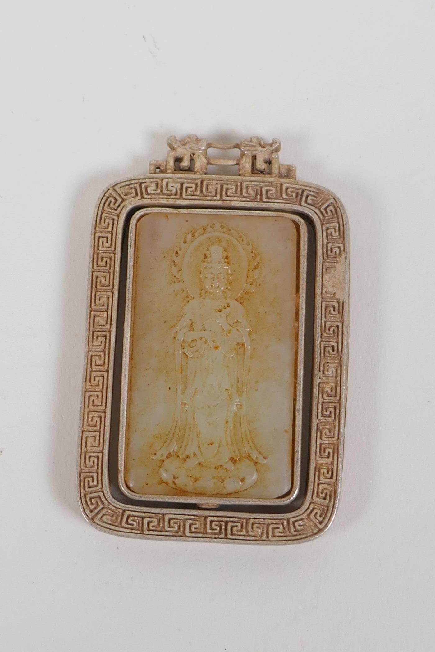 A Chinese white metal pendant set with a jade panel depicting Quan Yin, 4 x 6cms