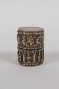 A Chinese white metal cylinder box and cover set with French coins and decorated with animals of the