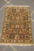 A Persian olive green wool rug with a mirrored paneled design, 142 x 202cms