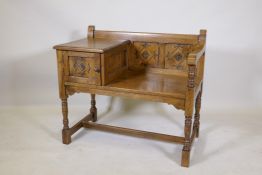 An oak hall settle, with carved panel back and cupboard, raised on turned supports, 87 x 50 x