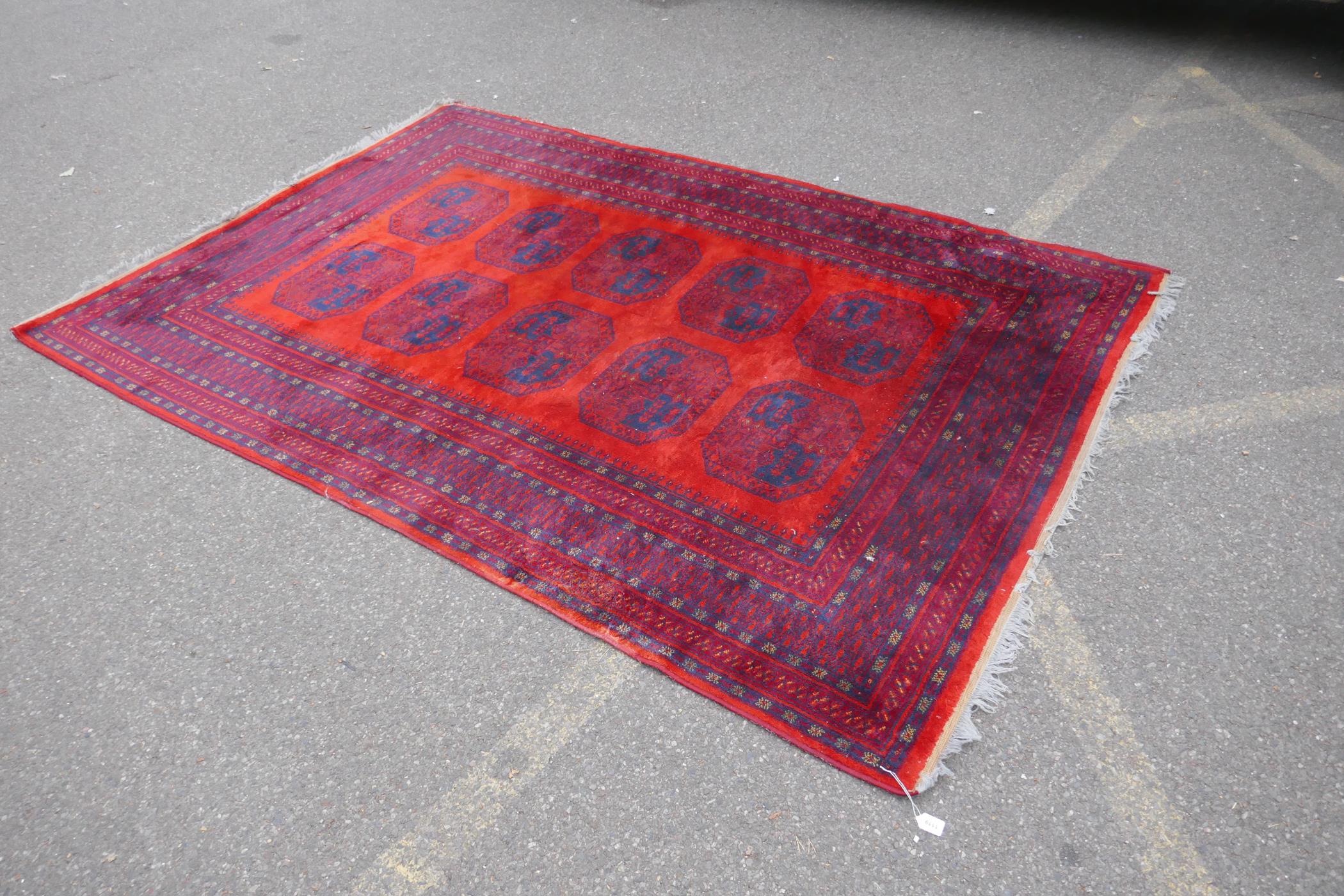 A Turkish Bokhara wool carpet with a tomato red field, 190 x 278cm - Image 2 of 5