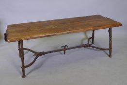 An oak plank top coffee table with wrought iron mounts and raised on a wrought iron base, 130 x 50 x