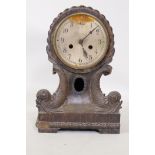 An antique oak cased mantel clock, with carved dolphin decoration, silvered copper dial and movement