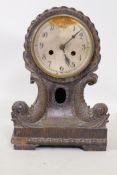 An antique oak cased mantel clock, with carved dolphin decoration, silvered copper dial and movement