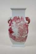 A red and white porcelain vase with two elephant mask handles, decorated with mountain landscape