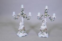 A pair of continental porcelain three branch candelabra marked to base, 44cm high