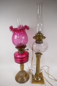 Two C19th brass column oil lamps converted to electricity, one with cranberry glass font and