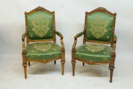 A pair of C19th French style carved walnut open arm chairs with shaped fronts