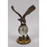 A desk top ball clock surmounted with a bronze figure of an eagle and two bronze rabbits to the