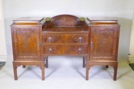 A 1930s mahogany Chippendale style pedestal sideboard with two cupboards flanking two drawers,