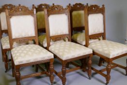 A good set of Victorian oak dining chairs with carved backs, raised on turned and fluted supports in