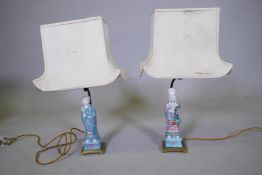 A pair of Chinese porcelain figured table lamps, mounted on brass bases, AF losses