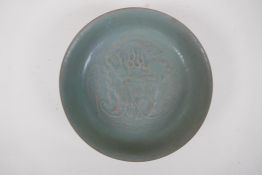 A Chinese celadon glazed porcelain dish with raised kylin decoration, 20cm diameter