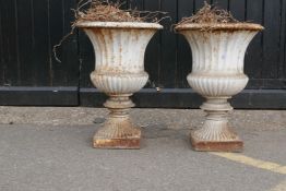 A pair of antique painted cast iron garden urns, 85cm high