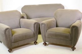 An Art Deco three piece suite, settee and two armchairs, well upholstered in a neutral fabric, 145cm