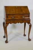 A Queen Anne style fall front bureau, with figured mahogany veneer, shaped interior fitted with four