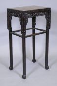 A Chinese hardwood table / plant stand with pierced and carved decoration on chamfered legs and