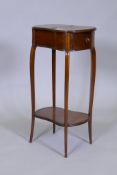 A mahogany kidney shaped two tier lamp table with single drawer and lift up top, raised on shaped