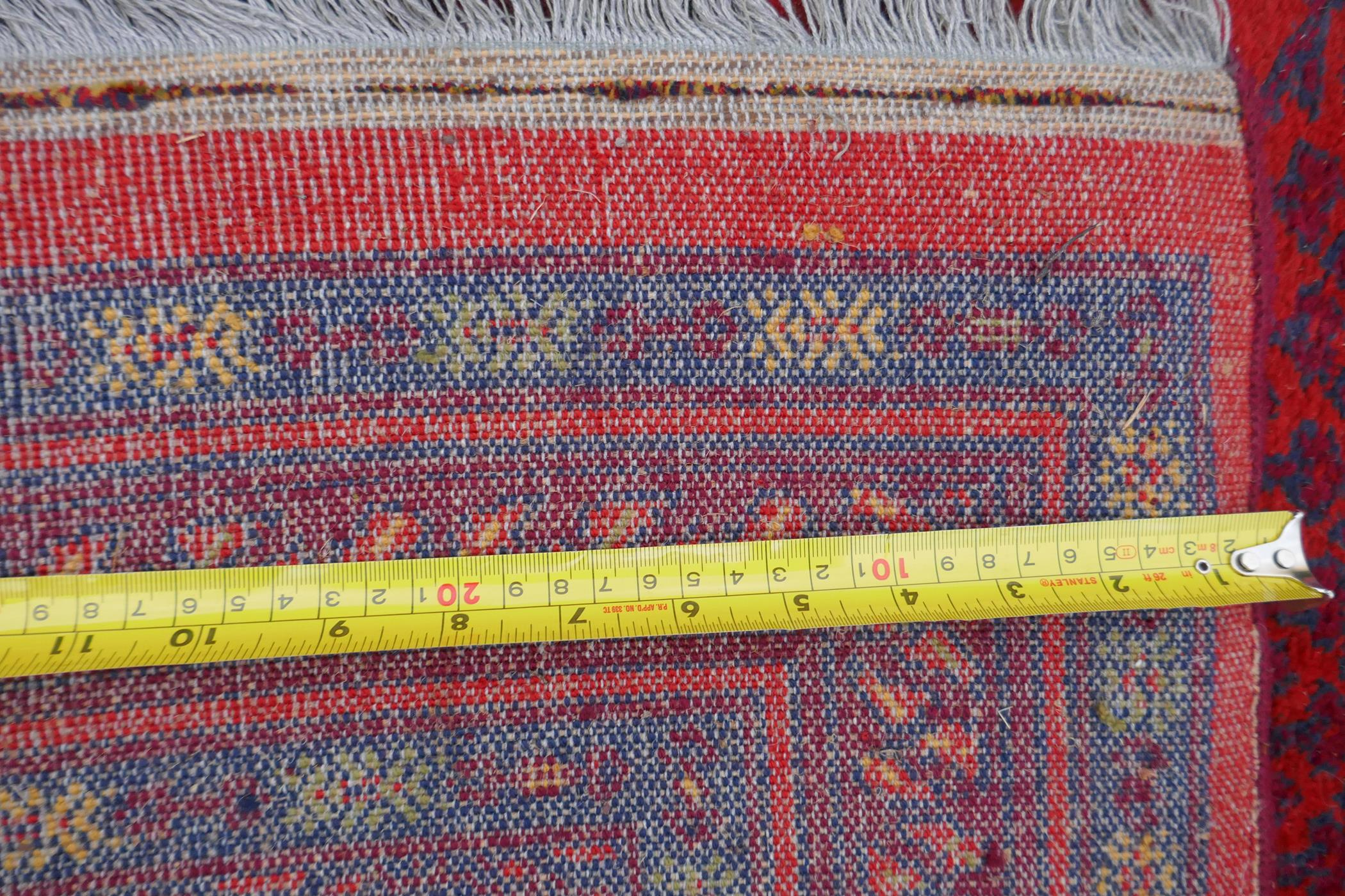 A Turkish Bokhara wool carpet with a tomato red field, 190 x 278cm - Image 5 of 5