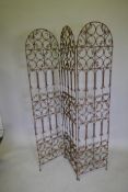 An arch top three fold iron garden screen with open scrollwork decoration, each panel 171 x 40cms