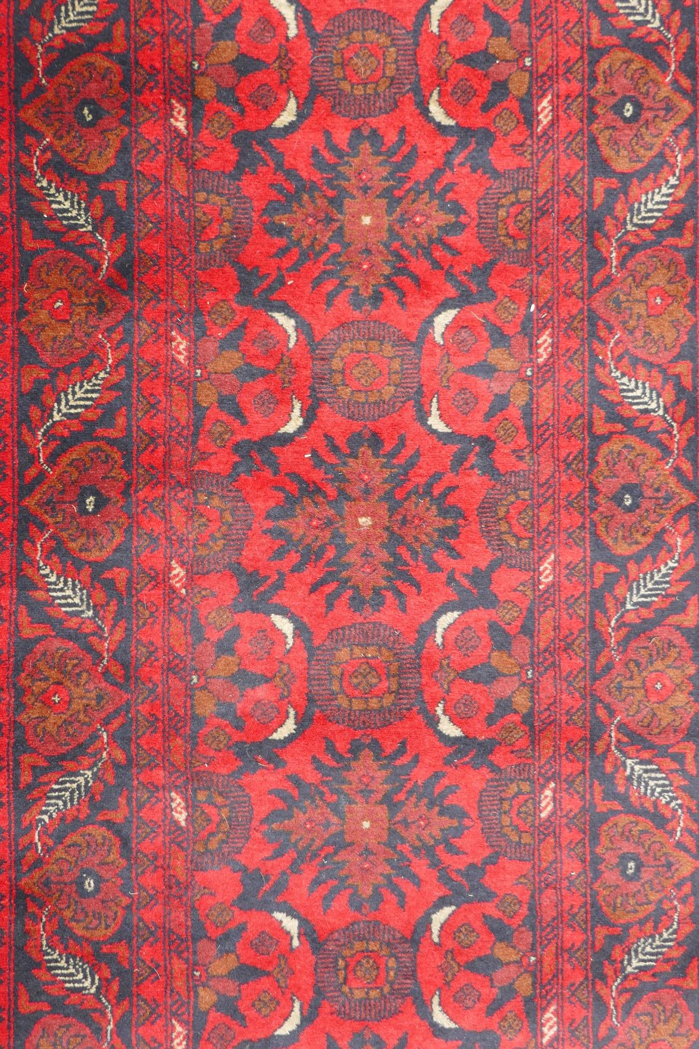 A Persian rich red ground wool runner with a floral medallion design and black borders, 33" x 116" - Image 3 of 5